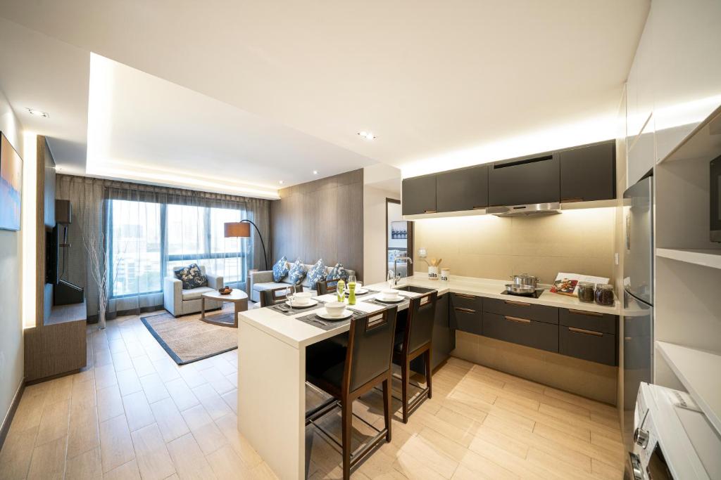 a kitchen and living room with a table and a couch at Oasia Residence Singapore by Far East Hospitality in Singapore