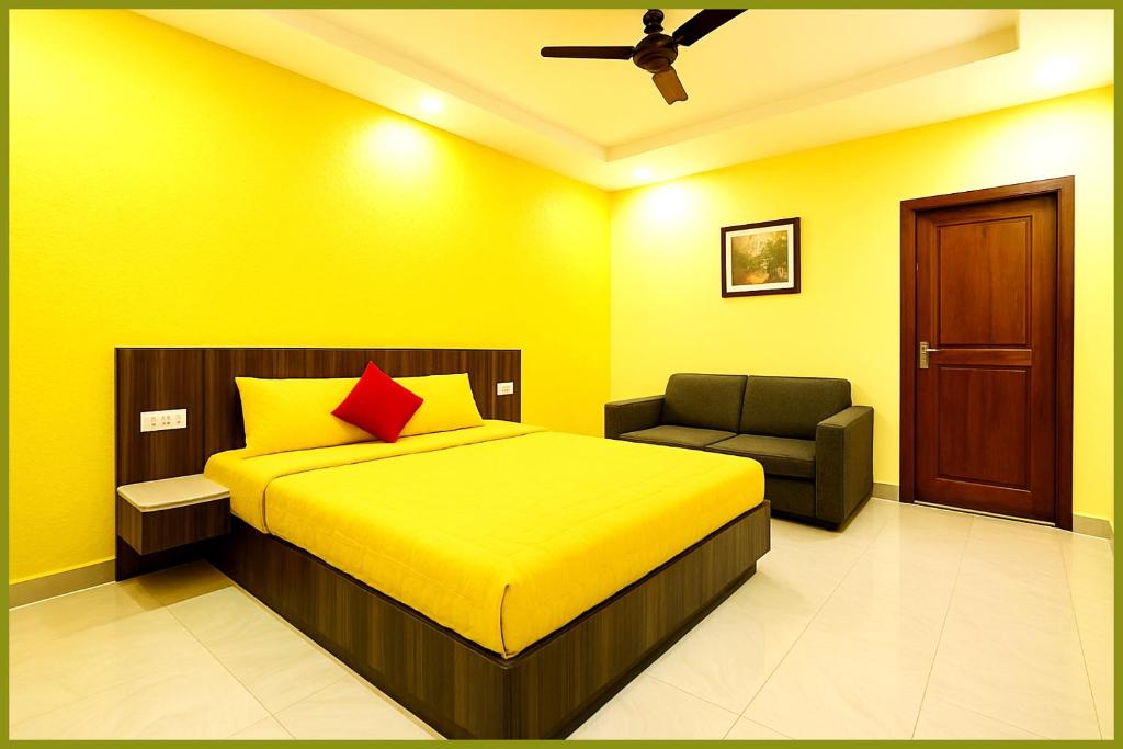 Dormitorio amarillo con cama y silla en Jagannath Temple Shashi Palace Resort - Fully Air conditioned# Free Wifi And Room Service #Budget Class Best Hotel IN Puri, en Puri