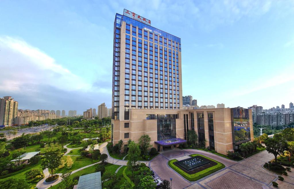 a tall building in a city with a park at San Po Hotel - Fuzhou Pushang in Fuzhou