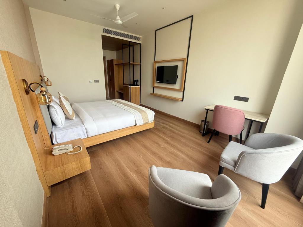 una habitación de hotel con una cama y una silla en Hotel HPB Grand, en Bhadohī