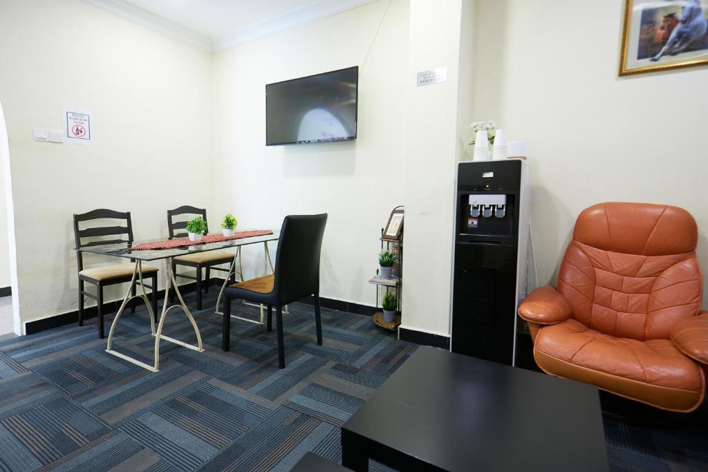 A compact reception or waiting area with café-style seating, a water dispenser and a lounge chair.