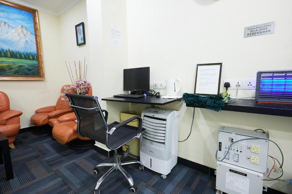 A small office workspace combines a computer desk, office chair, printer equipment and lounge seating.