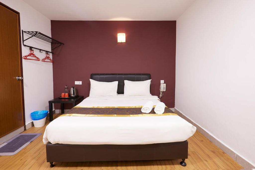 A front-facing view of a compact double room with open clothes rails and a kettle station.
