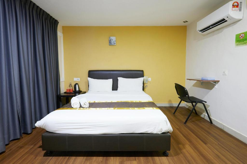 A yellow-accented double room with a wall-mounted shelf desk and full-height curtains.