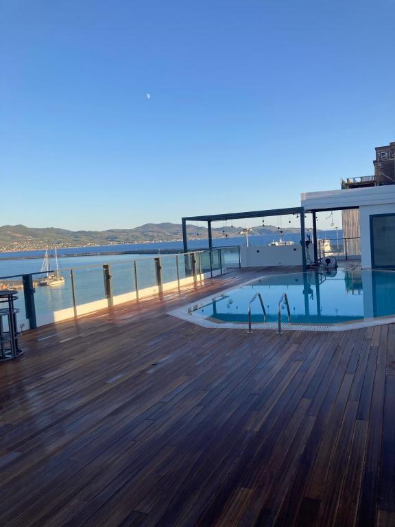 eine Holzterrasse mit Blick auf das Wasser in der Unterkunft Elektra Roof Top Suite in Kalamata