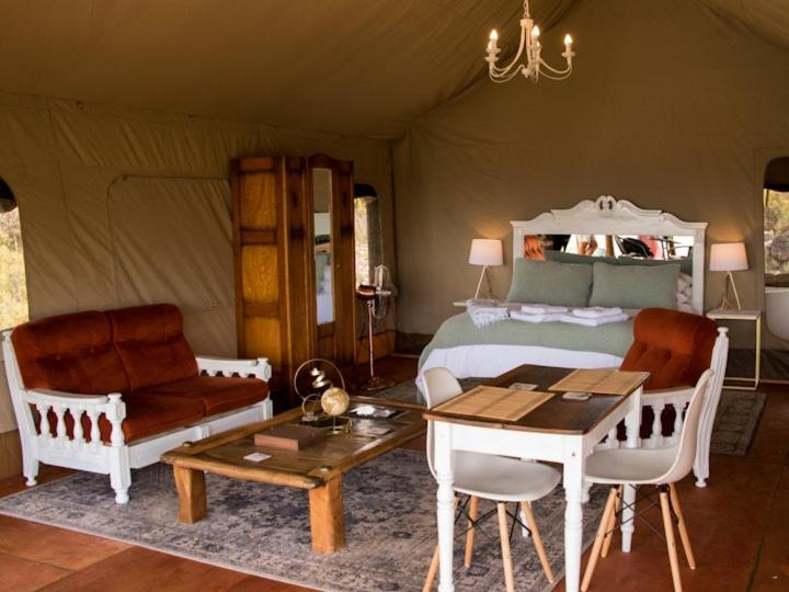 a bedroom with a bed and a table and chairs at Majestic wonders in Knysna