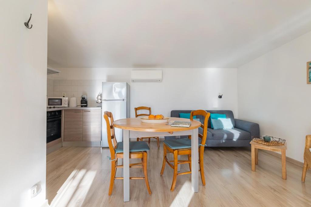 La Miellerie في جيرو-لي-بان: مطبخ وغرفة طعام مع طاولة وكراسي