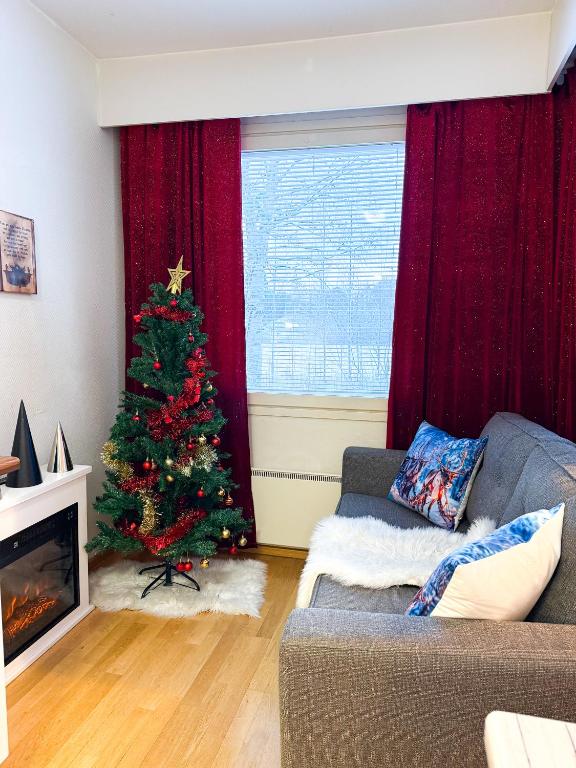 a living room with a christmas tree and a couch at Large Group Fireside Cabin in Rovaniemi