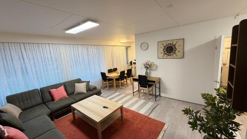 a living room with a couch and a table at Private House with Sauna and Winter Garden in Helsinki