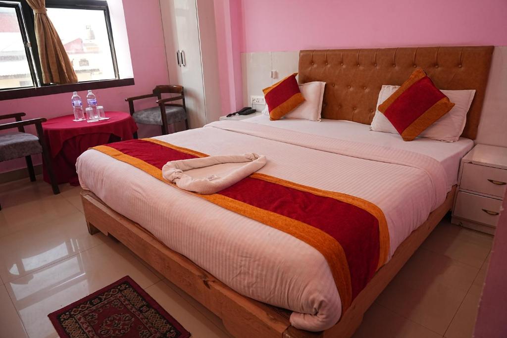 a bedroom with a large bed in a pink room at Hotel Ganga Sagar in Kathmandu