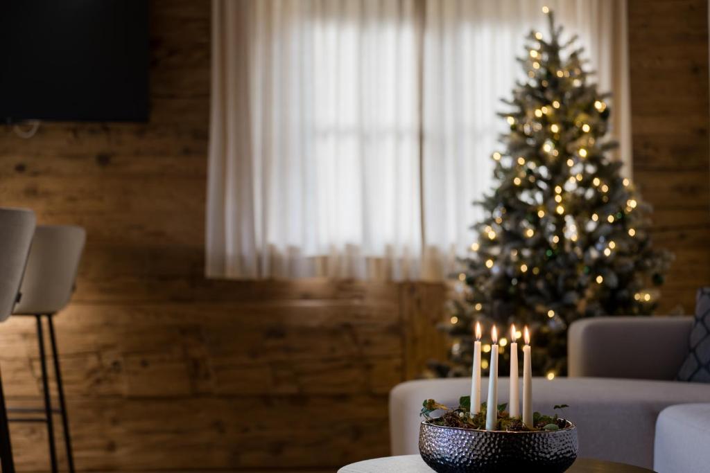 a christmas tree in a living room with lit candles at Arnestgut in Strobl