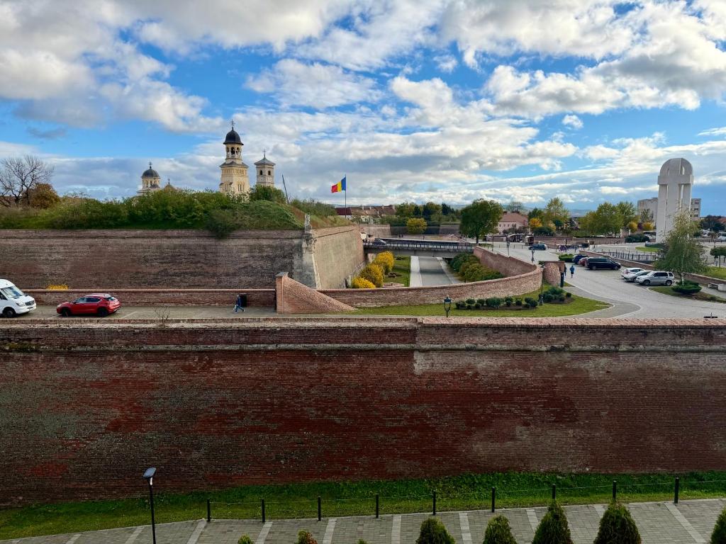 a large brick wall in a city with a street at Dante Residence in Alba Iulia