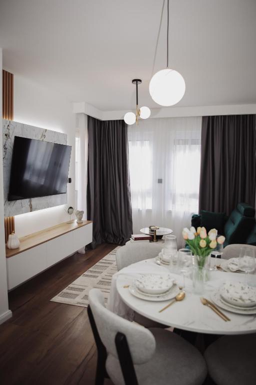 a living room with a white table and chairs at Apartman Monet in Pale