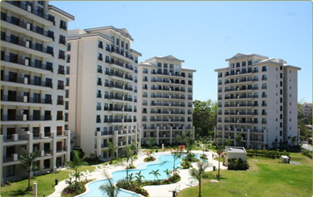 an aerial view of three apartment buildings with a pool at Condominio 8vo Piso, Jaco Bay in Jacó