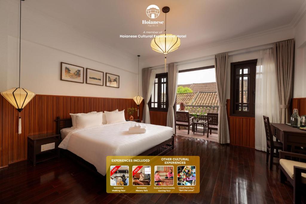ホイアンにあるHoianese Tranquil Heritage Hotel - Truly Cultural Immersionのベッドと机と窓があるホテルの部屋