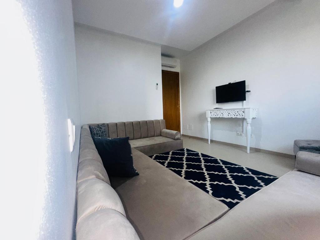 un salon avec un canapé et une télévision à écran plat dans l'établissement Safa, à Tunis