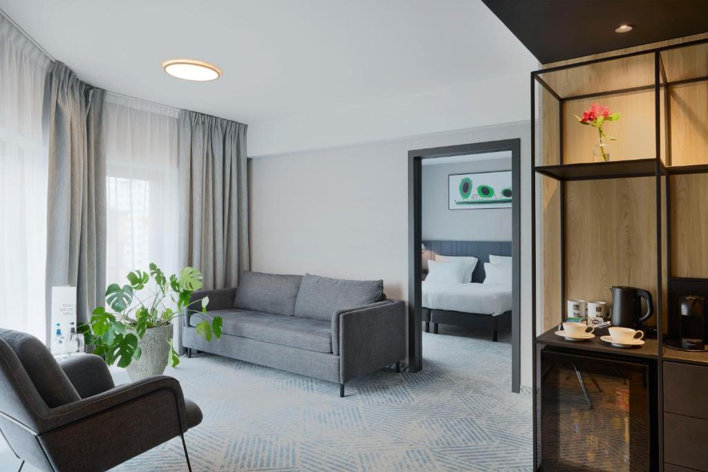 弗罗茨瓦夫加弗罗茨瓦夫Q酒店的带沙发的客厅和卧室