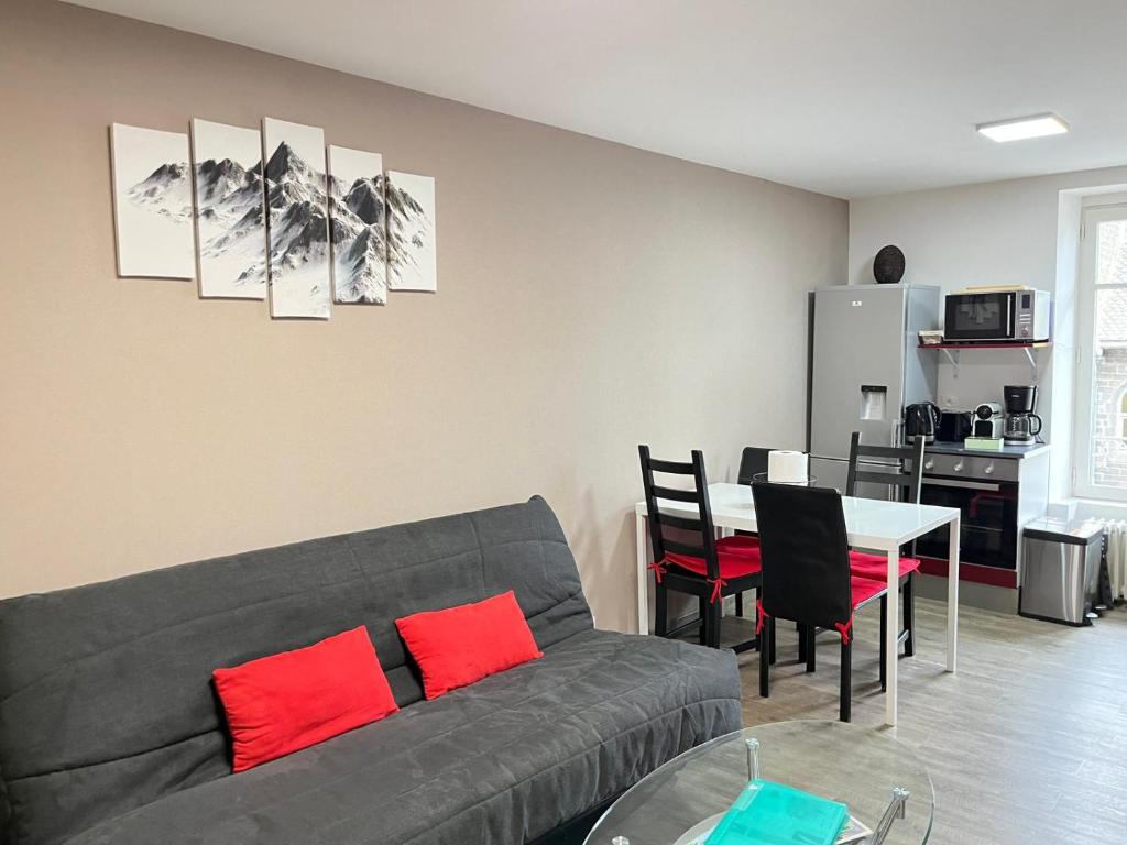 a living room with a couch and a table with red pillows at Villa Blanche appartement 2 in Le Mont-Dore