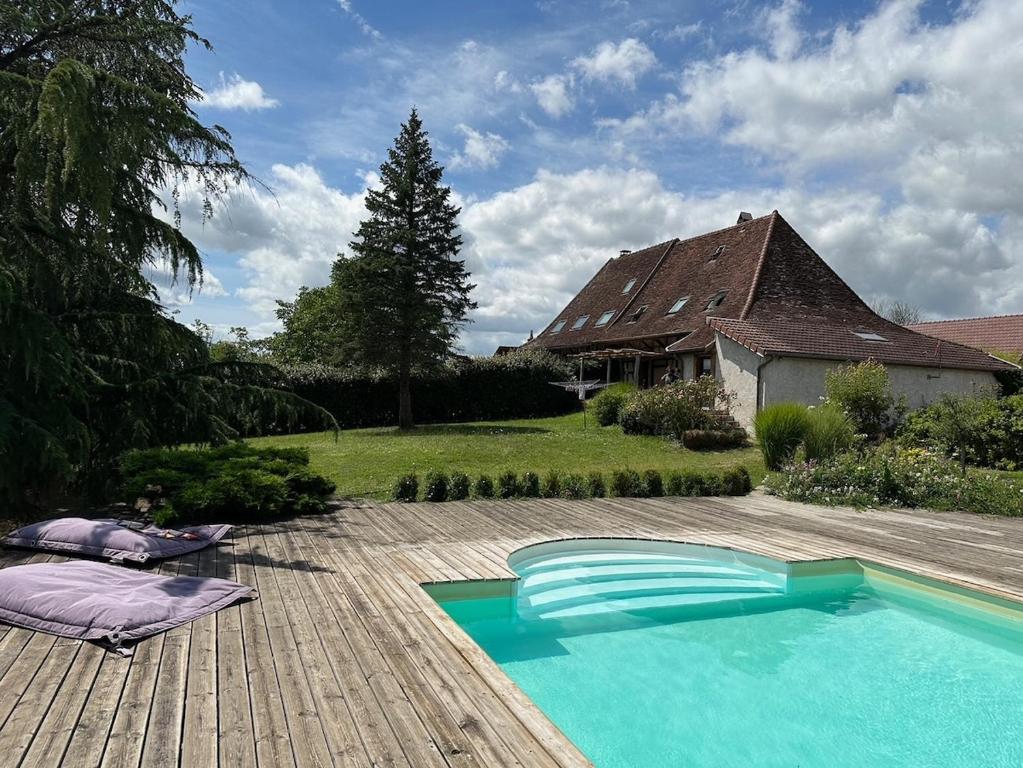 einen Pool auf einer Holzterrasse neben einem Haus in der Unterkunft Maison Manoé in Sens sur Seille