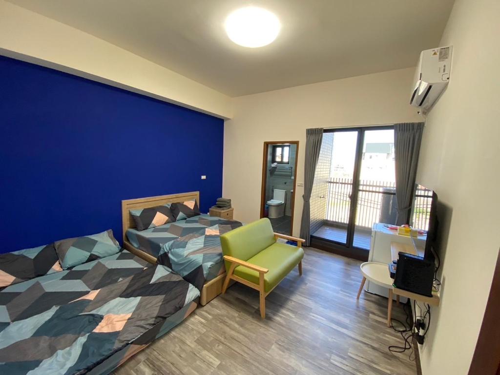 a bedroom with a bed and a chair and a window at 前寓民宿 in Donggang