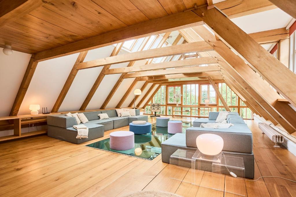 an attic living room with wooden ceilings and blue couches at Das Wewelsflether Bäckerhaus - 250qm für 12 Gäste in Wewelsfleth