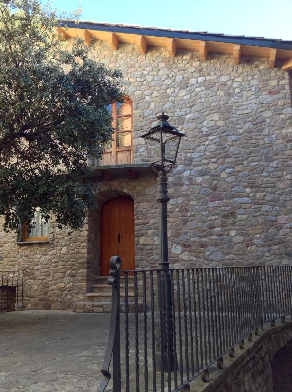 a street light in front of a stone building with a door at Can Xuneta in Bagá