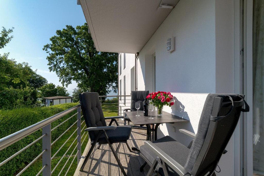 萨斯尼茨Villa Nause-FeWo Buchenfreund mit Spa und Freizeit的阳台上配有桌椅的露台
