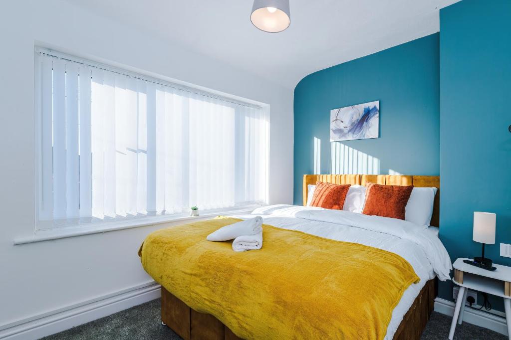 a bedroom with a large bed with a yellow blanket at Contractor Heaven Four Bedroom Free Parking in Manchester by Eason Stays in Little Hulton