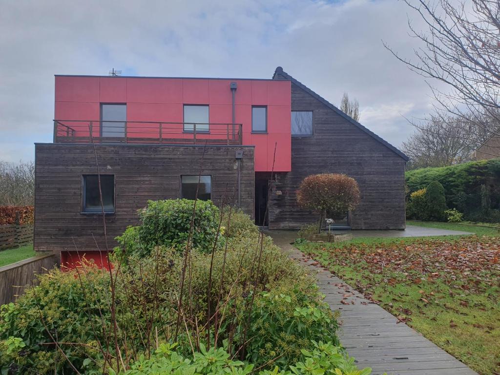 a house with a red wall on top of it at comme chez nous 