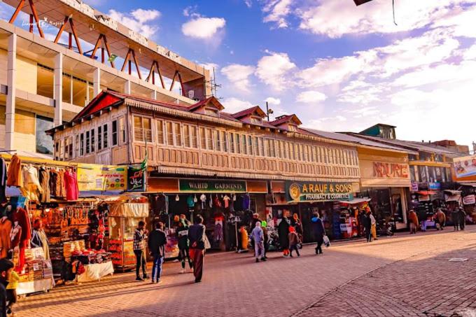 Un groupe de personnes marchant dans une rue d'un marché dans l'établissement Al Maz Hotel Mall Road, à Dargai