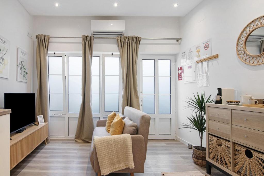 a living room with a chair and a television at Central Studio – Flor De Sol in Tavira