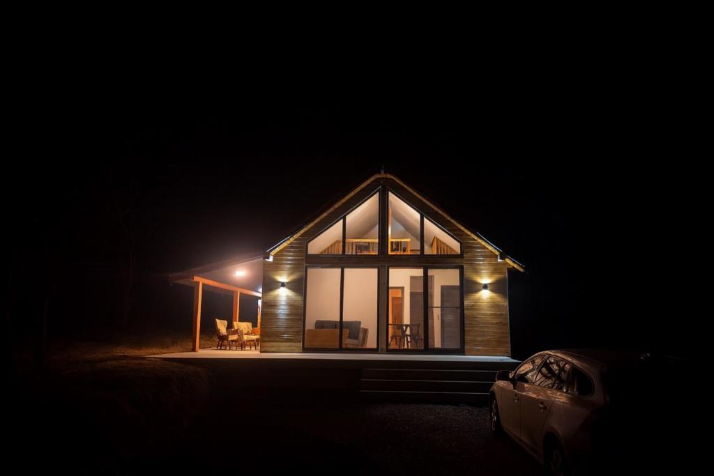 a small house at night with a car parked in front at Arbor in Vadul lui Carol II