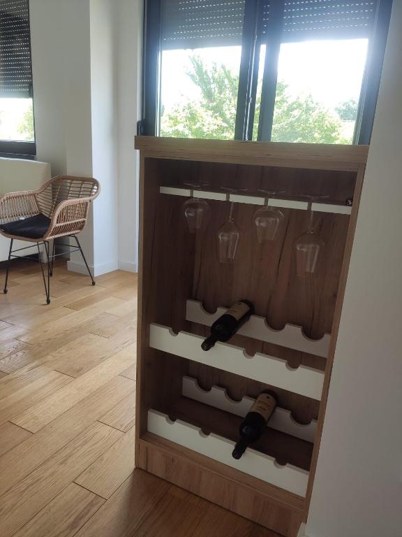 a wine rack with wine bottles and wine glasses at Xenia in Petrovaradin