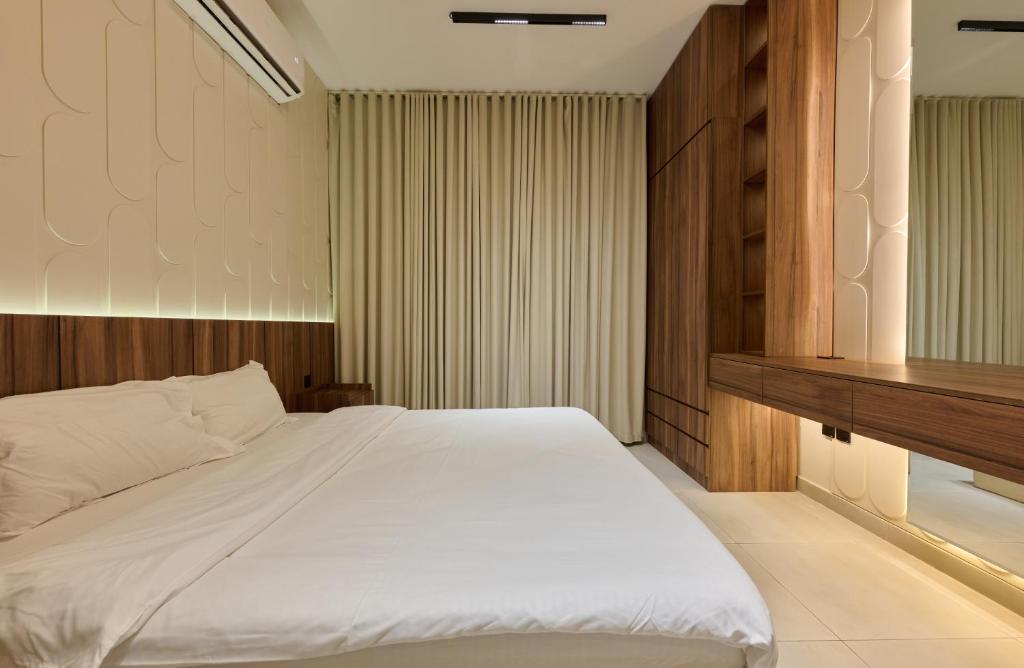 a bedroom with a large white bed and a desk at Khorfakan homes by the Living in Khor Fakkan