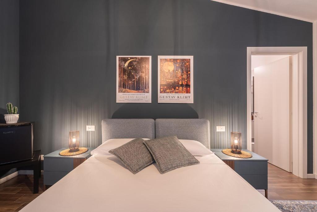 a bedroom with a white bed with three pictures on the wall at 3 MURA rooms in Teulada