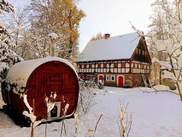 eine Scheune im Schnee neben einem Haus in der Unterkunft Chatka zimorodka in Pielgrzymka