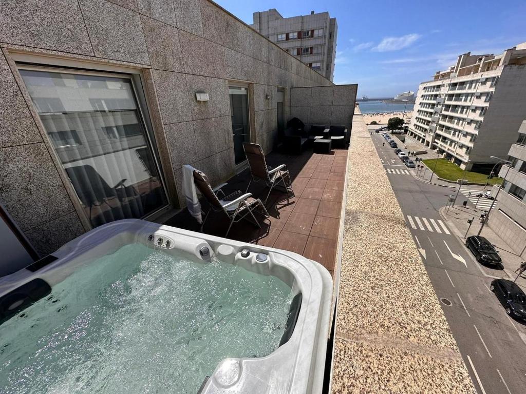 a hot tub on the side of a building with chairs at Luxury Rooftop Apartment by LuxiStay – Private Jacuzzi & Sunset Views | Matosinhos in Matosinhos
