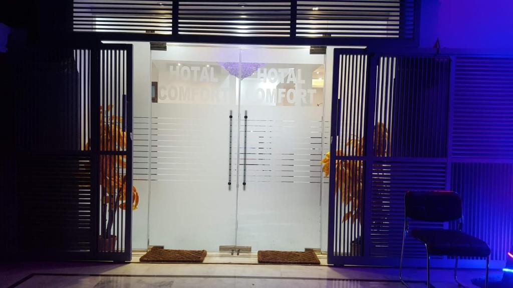 DargaiにあるHotel Comfort Innの椅子付きの部屋のガラスドア