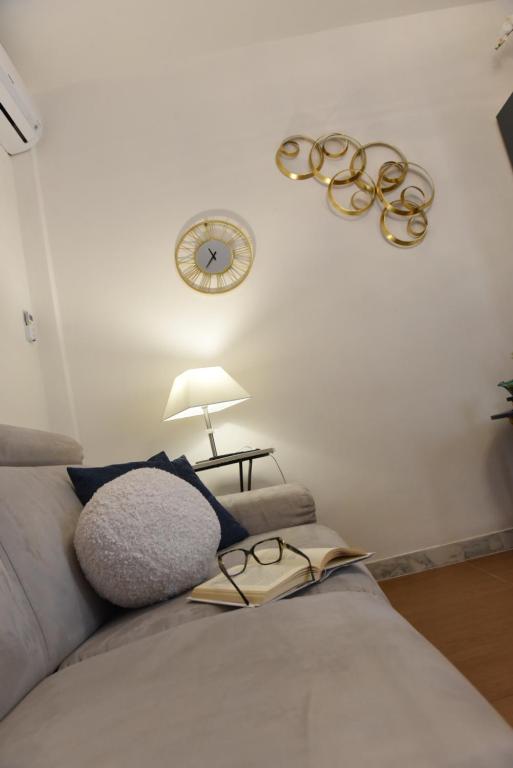 ein Zimmer mit einem Sofa und einer Uhr an der Wand in der Unterkunft La Perla Di Caserta in Caserta