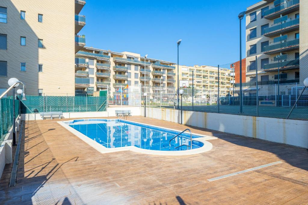 una piscina frente a un edificio de apartamentos en Apartamentos ALBENIZ - La Pineda Platja, en La Pineda