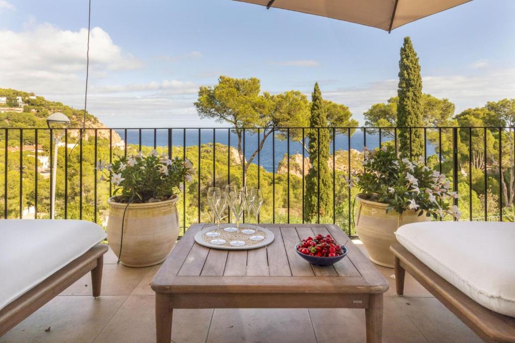 a patio with a table and a balcony with a view at Cala Nostra Bea in Palafrugell