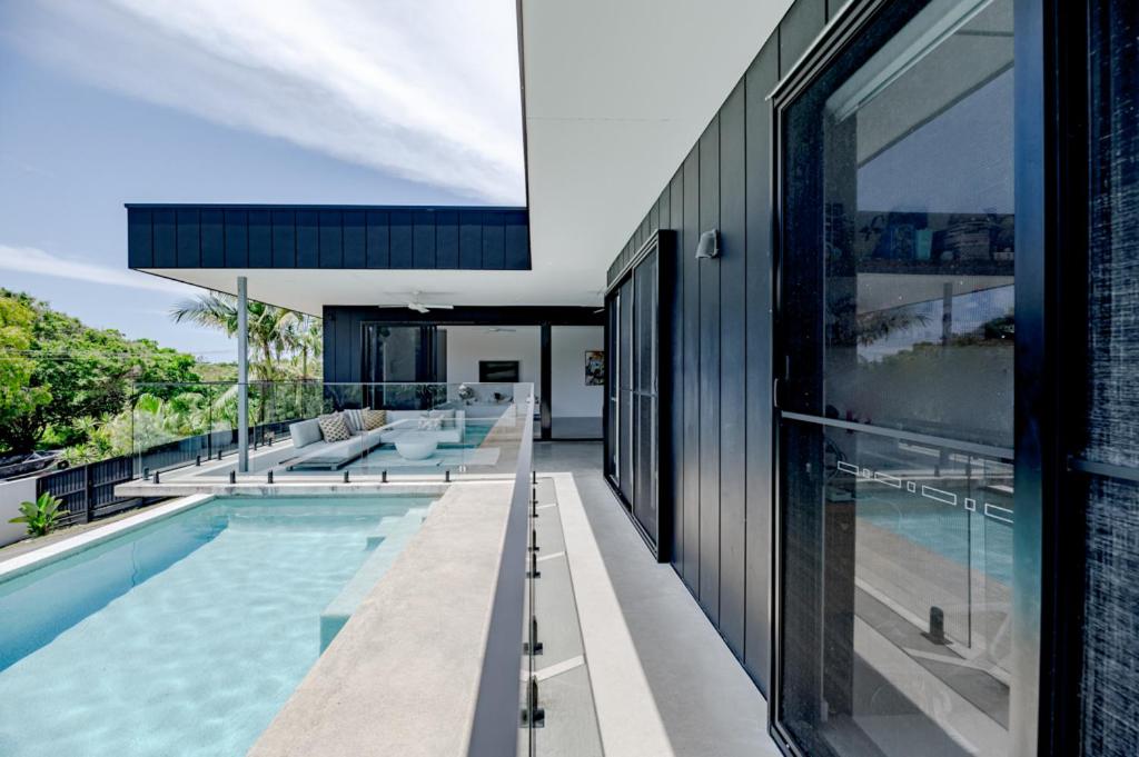 une maison ouverte avec une piscine et une maison dans l'établissement Mimosa by the Beach, à Peregian Beach