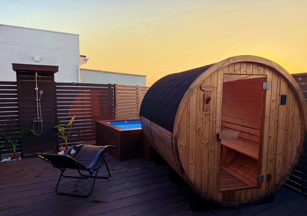 un grand bâtiment en bois sur une terrasse avec une chaise dans l'établissement Kubikai, à Itoshima