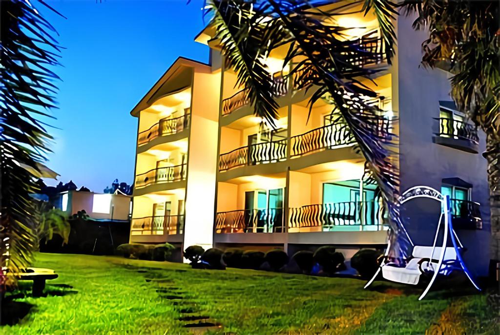 un grand bâtiment avec une pelouse devant dans l'établissement Jeju Castle, à Seogwipo
