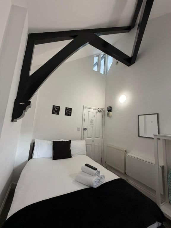 a bedroom with a black and white bed and a window at TLK Apartments & Hotel - Beckenham in Beckenham