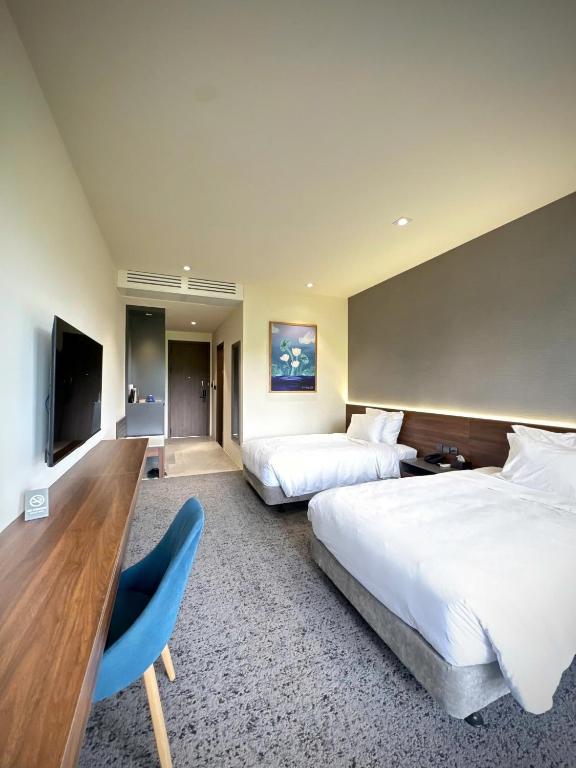 a hotel room with two beds and a tv at Mountain Hill in Mai Sơn
