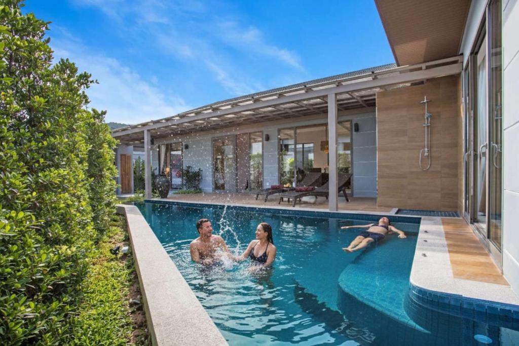 3 personnes dans la piscine d'une maison dans l'établissement Modern Eco Pool Villa Dalaa 7, à Kamala Beach