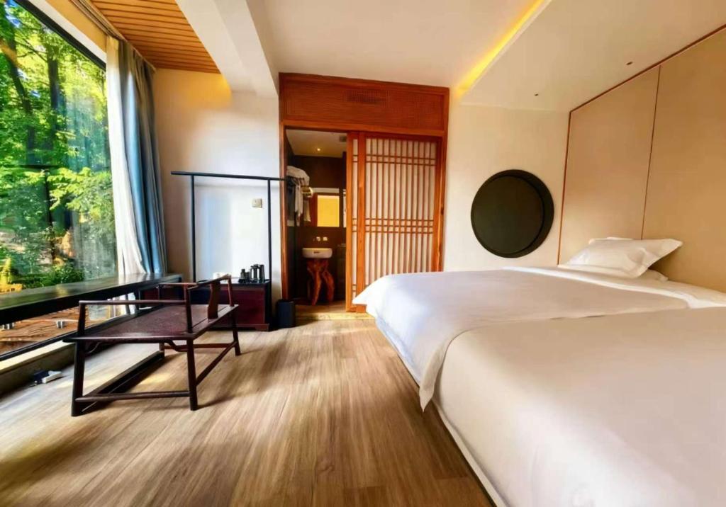 een slaapkamer met twee bedden, een bureau en een raam bij Guilin Xi'an Hotel in Guilin
