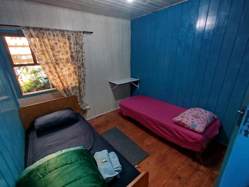 a small room with a bed and a window at Quarto N II Cama Individual e sofá cama solteiro in Gramado