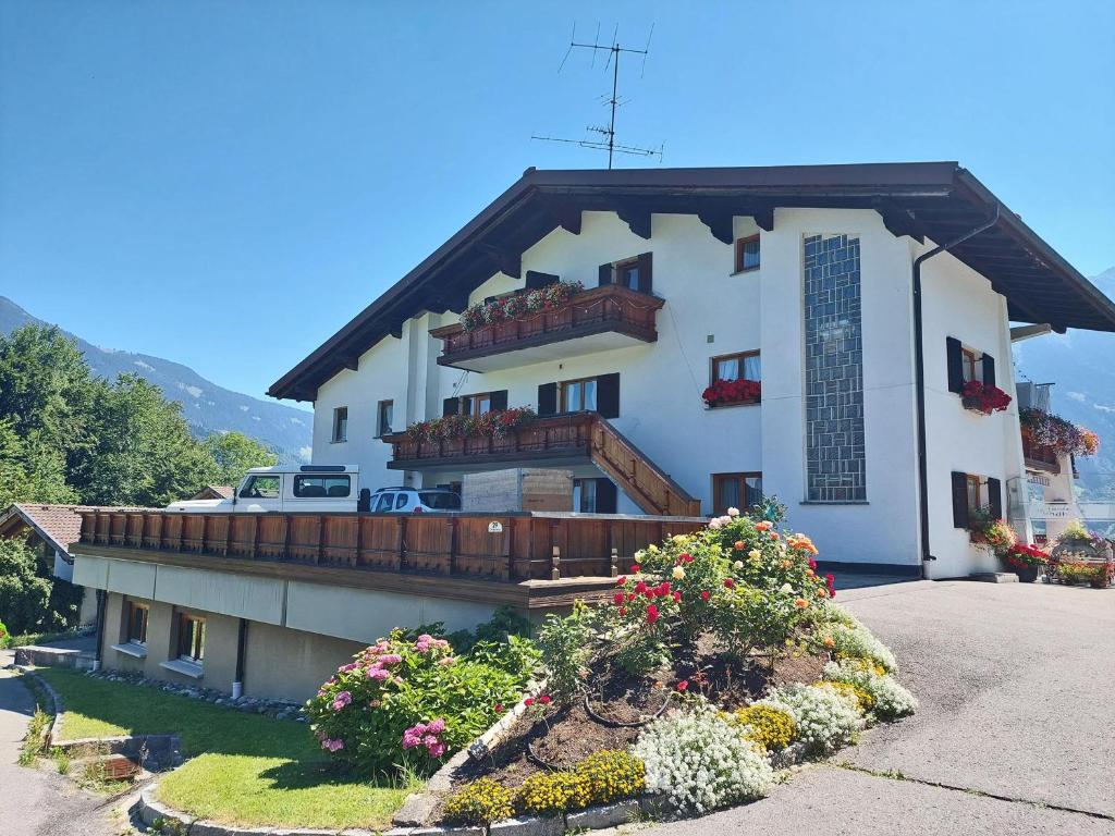 a large white house with a balcony and flowers at Rundblick 3 Panorama Klein in Tschagguns